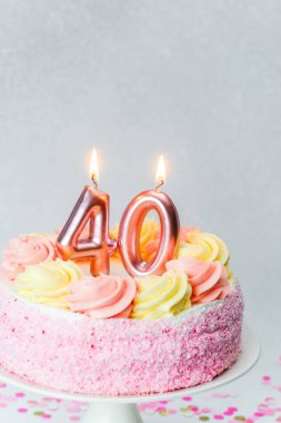 Güzel dekore edilmiş, pembe şekerli ve mumlu bir pasta 40. yaş günümü simgeliyor..
