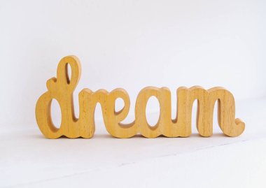 Tahta kelime 'rüya' beyaz bir yüzey üzerinde duruyor temiz bir arka plan, basit bir zarafet