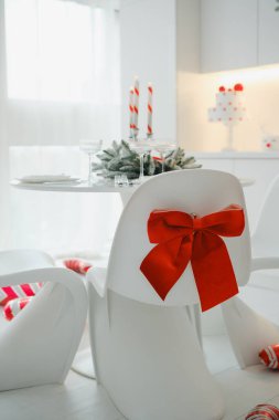 Bayram sofrasında mumlar, hediye kutuları ve kırmızı kurdele ve noktalarla süslenmiş bir pasta..