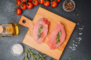 Biberiyeli dana bifteği, ahşap kesim tahtası ve yemek malzemesi.