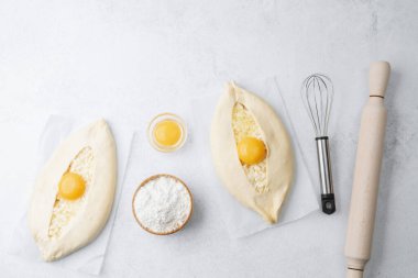 Yumurta sarısı ve beyaz arka planda çırpılmamış khachapuri.