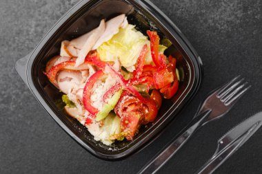 Sağlıklı öğle yemeği veya diyet menüsü konsepti için marul domates kırmızı biber ve parmesan soslu hindi salatası.