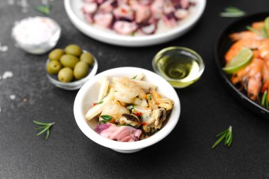 Tapas veya gastro bar konsepti için karides salatası ve deniz ürünleri karışımı siyah kase.