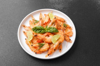İtalyan deniz ürünleri veya sağlıklı yemek için seramik tabakta taze fesleğenli karides.