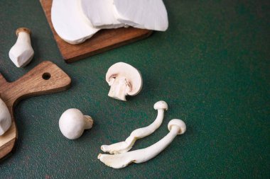 Hasat çeşitliliği veya vejetaryen pişirme konsepti için koyu yeşil arka planı olan çeşitli mantarlar.