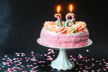 Pembe şekerli ve mumlu güzel doğum günü pastası bir dönüm noktasını kutluyor..