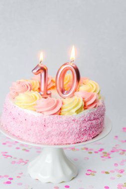 Nefis bir doğum günü pastası pembe şekerleme ve iki parlayan mum içerir..