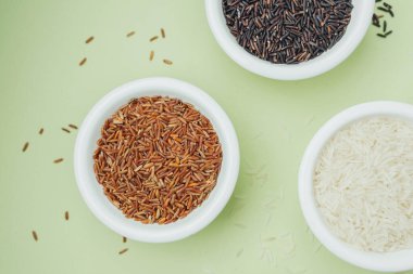 Yeşil zemin üzerinde seramik kaselerde siyah ve beyaz pirinç manzarası