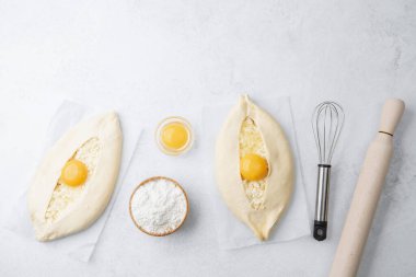 Yumurta sarısı ve beyaz arka planda çırpılmamış khachapuri.