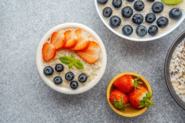 Yulaf ezmeli yulaf lapası, çilekli yaban mersini ve naneli beyaz kâse.