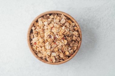 Yuvarlak ahşap kase ve arka planda granola yakın plan