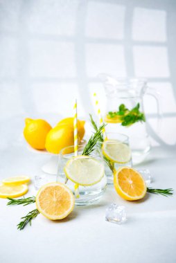Biberiyeli limon suyu, sarı çizgili kamışlar ve naneli ve buzlu taze limon parçaları.