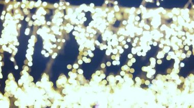 Ilık altın bulanık ışıklar karanlık bir arka planda güzel sihirli yumuşak bokeh efekti yaratır..