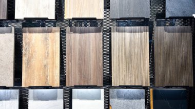 Çeşitli doğal ahşap görünüm ve taş dokusu seramik fayans örnekleri ağ şebekesi duvarında sergilenmektedir..