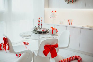 Kırmızı kurdeleli beyaz masa ayarı, baston şekerler ve bayram kutlamaları için hediyeler.