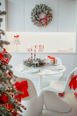 Şenlikli dekorlu, hediyeli ve beyaz sandalyeli zarif bir Noel sofrası. 94 sembol.