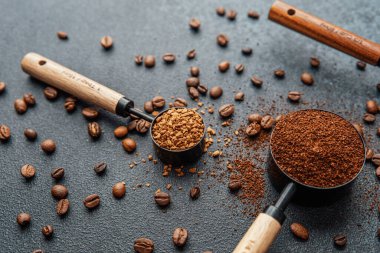 Ground Coffee ve gri arka planda kepçeli fasulyeler.