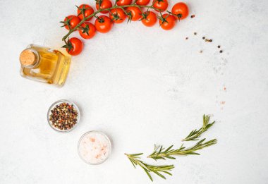 Beyaz arka planda domates, zeytinyağı, tuz, biber ve biberiye karışımı.