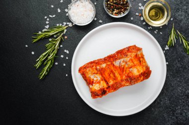 Beyaz tabakta marine edilmiş domuz pirzolası ve baharat.