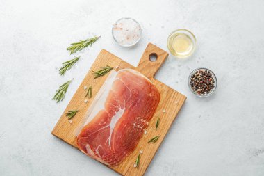 Jambon dilimleri tuz, otlar ve baharatlarla dilimlenmiş.