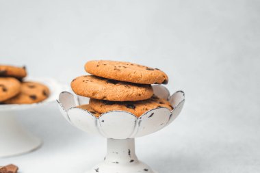 Sıcak bir mutfaktaki eski bir standın üzerinde taze pişmiş çikolatalı kurabiyeler..