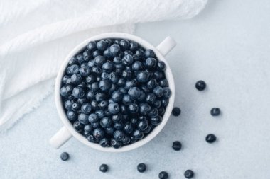 Rahatlık, diyet veya organik yeme konsepti için yumuşak kumaşlı yaban mersini kasesi.