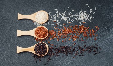 Siyah desenli yüzeyde siyah ve beyaz pirinçli kaşıklar.