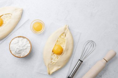 Yumurta sarısı ve beyaz arka planda çırpılmamış khachapuri.