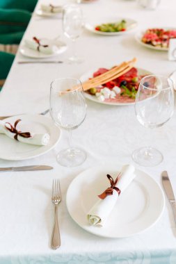 Tabakları, bardakları ve taze yiyecekleri olan misafirler için güzel bir masa..