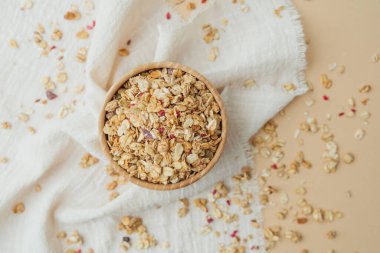 Tahta kasede yumuşak beyaz kumaş arka planda granola.
