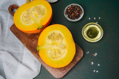 Tahtada yarım balkabağı, yağlı ve biberli tohumlar pişmeye hazır.