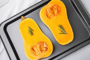 Biberiye filizli tereyağlı kabak yarımları pişirme çarşafında hazır.