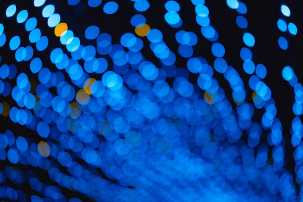 Bulanık mavi ve altın ışıklı tünel deseni koyu arkaplan, soyut parlayan daireler