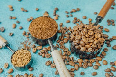 Kahve, hazır kahve ve mavi arka planda kepçelerle fasulye.