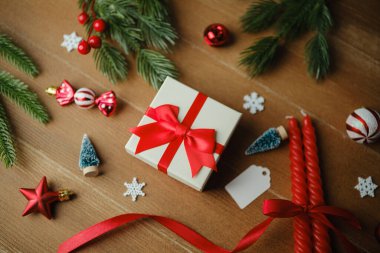 Noel hediye kutusu kurdelesi kırmızı süslemeler ahşap masa dalları tatil sezonu hazırlanıyor.