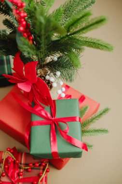 Kırmızı kurdeleli Noel ağacı dalı ve kırmızı kurdeleli hediyelerin yanında böğürtlen