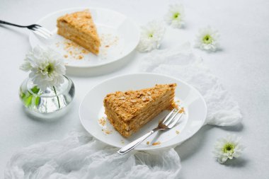 Napolyon keki beyaz tabakta krema ve puf böreği katmanlı tatlı ile dilimler.