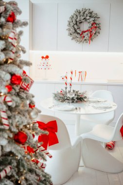 Şenlikli ağaç, çelenk ve neşe dolu süslemeleri olan zarif mutfak masası..