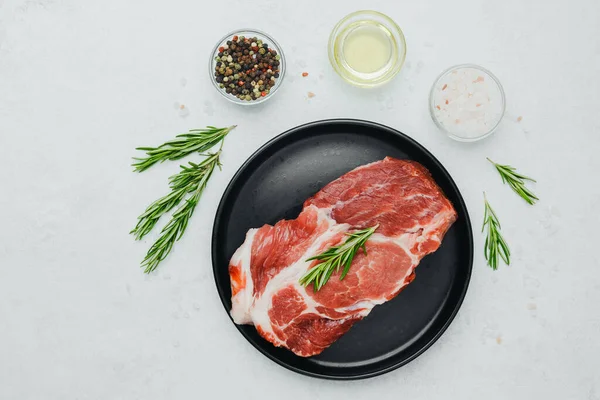 Biberiyeli domuz bifteği, siyah tabakta baharatlı.