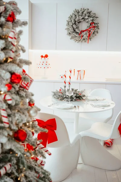 Şenlikli ağaç, çelenk ve neşe dolu süslemeleri olan zarif mutfak masası..