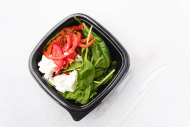 Vejetaryen öğle yemeği veya sağlıklı beslenme konsepti için kurutulmuş domates peyniri ve kırmızı biberli ıspanak salatası.