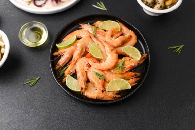 Aperatif ya da atıştırmalık konsepti için siyah kasede limonlu karides ve zeytin.