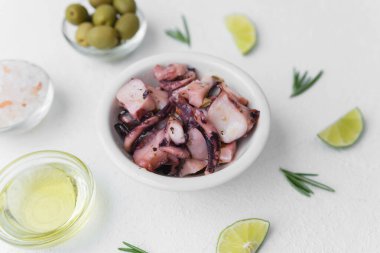 Taze deniz ürünleri veya aperatif yemek konsepti için zeytin ve sosla marine edilmiş ahtapot.
