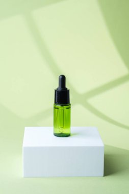 Siyah kapaklı yeşil kozmetik cam damlası şişesi.