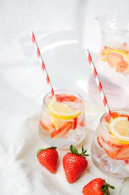 Limon dilimli taze narenciye ve yumuşak havluyla servis edilen buzlu buzlu buzlu meyve suyu.