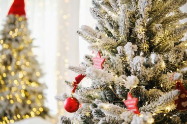 Yumuşak kar ve parlak sıcak ışıklarla süslenmiş ebedi yeşil dallar, şenlikli bayram mevsimi