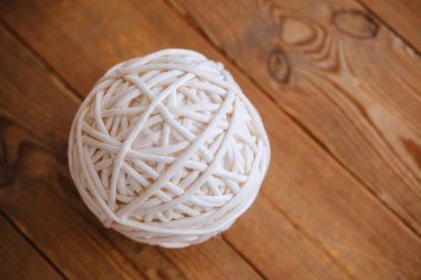 Beyaz tişört yumağı kopyalanmış ahşap bir yüzeyde duruyor.