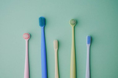 Beş renkli diş fırçası düz bir yüzeyde duruyor.