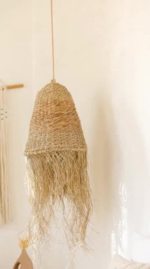 İç mekanda asılı yıpranmış kenarlı el yapımı jüt kolye lambası tarafsız oda