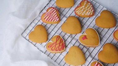 Kalp şeklinde zencefilli kurabiye. Sevgililer günü için tel askıda soğuyor.